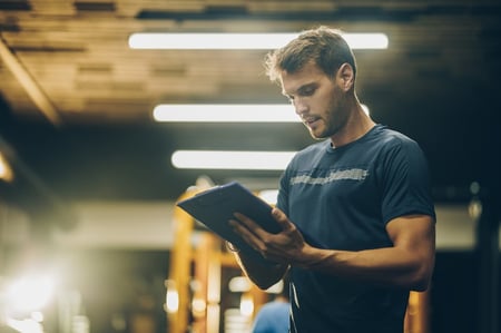 Former athlete turned personal trainer looking at a clipboard