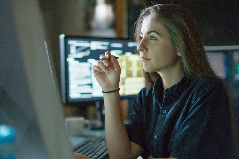 Young female data scientist sitting at a computer